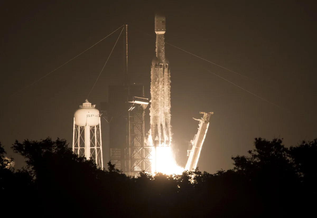 En Falcon Heavy-rakett fra SpaceX letter i mørket fra Kennedy Space Center