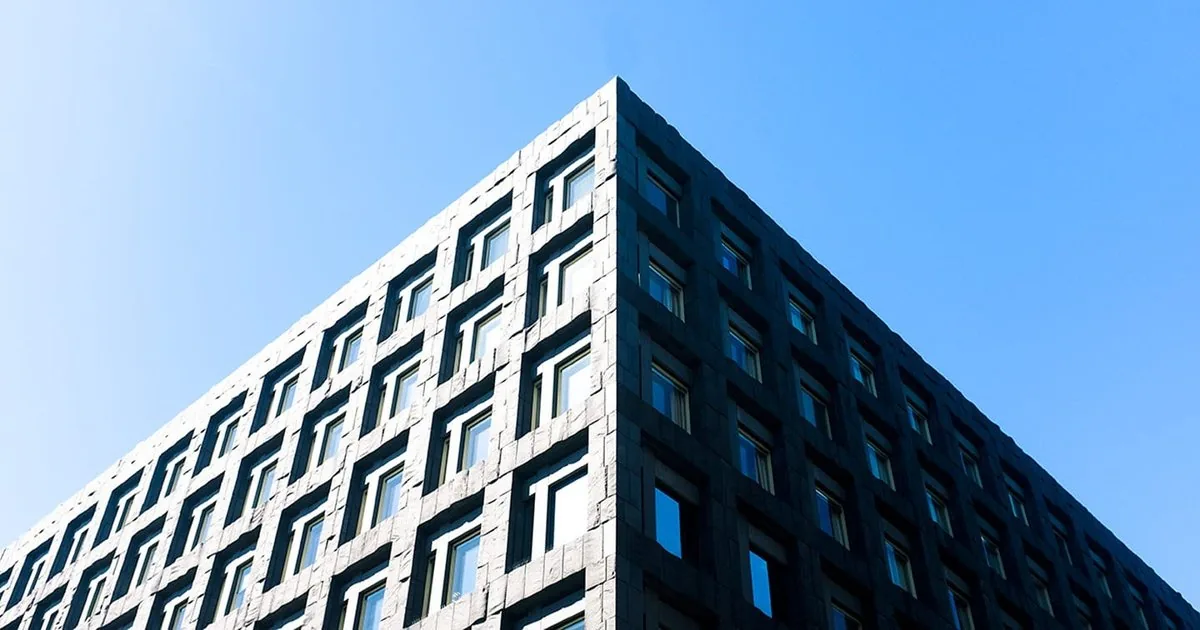 Riksbankens hovedkontor i Stockholm sett nedenfra mot en blå himmel