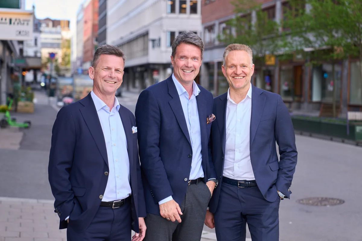 Tre ledere fra Sparebanken Norge og Oslofjord Sparebank fotografert sammen i en bygate