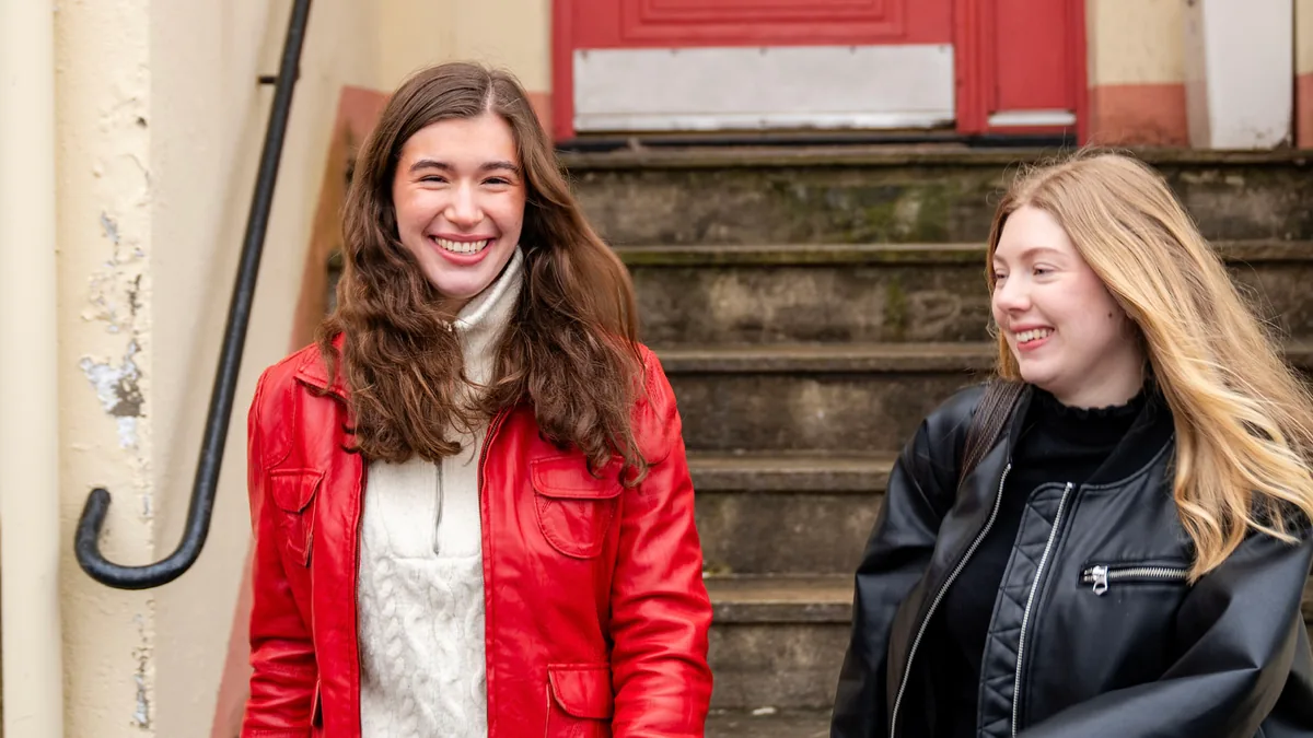 To kunder i Sparebanken Norge fotografert på en trapp i en bygate