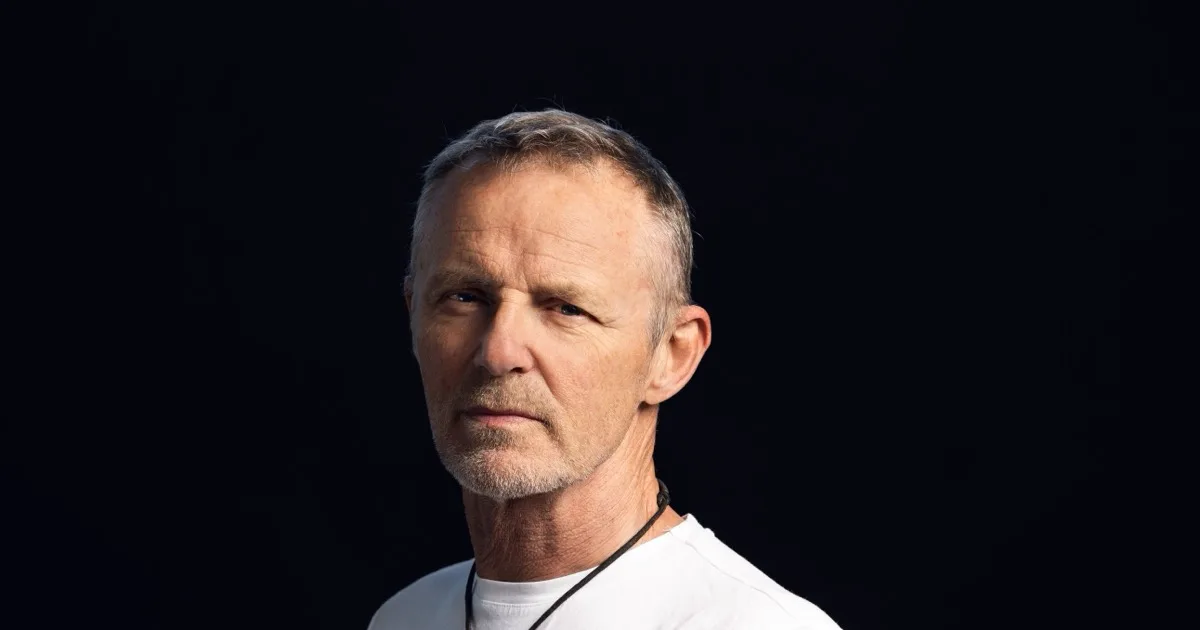 Portrett av forfatteren Jo Nesbø i hvit T-skjorte mot svart bakgrunn
